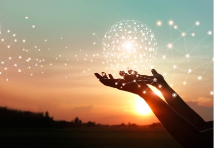 Two hands holding a globe made of stars with a blue and orange dusk in the background